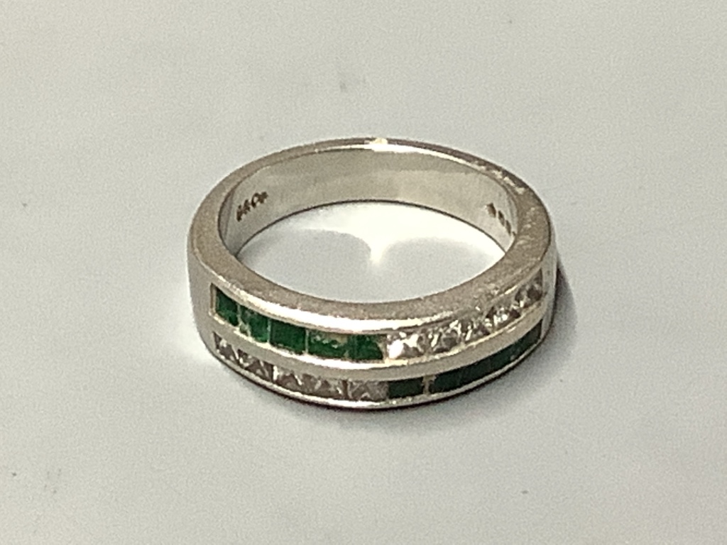 A platinum, emerald and diamond ring
